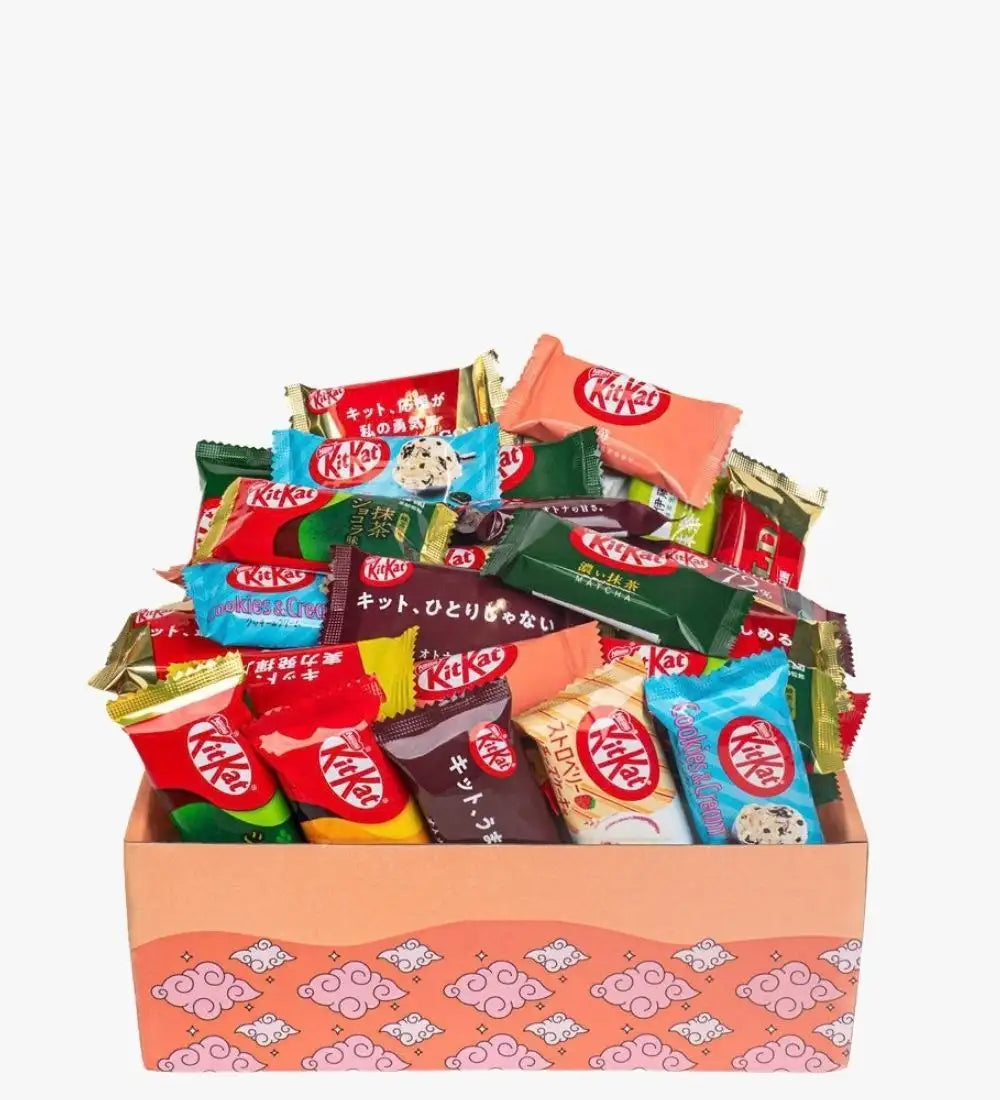 Un assortiment vibrant de barres de chocolat KitKat aux saveurs variées et à des emballages colorés, nichées dans une boîte cadeau rose à motifs.