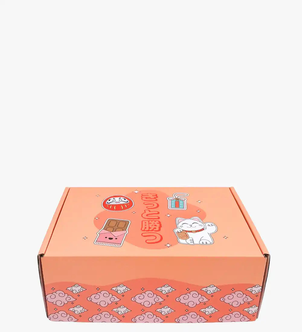 Boîte de couleur pêche avec un design de chat cartoon et du texte japonais.